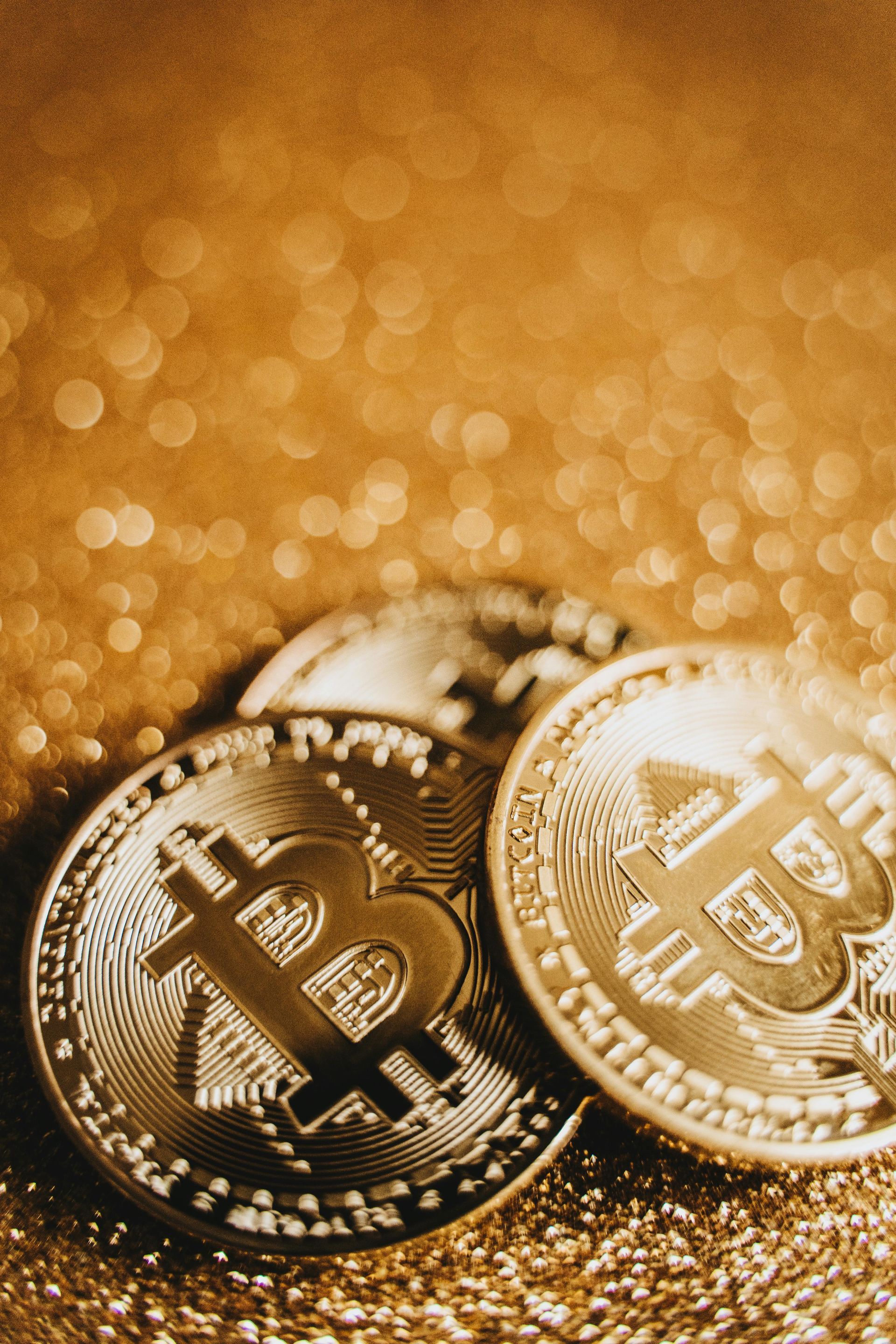 three bitcoins over dust of gold